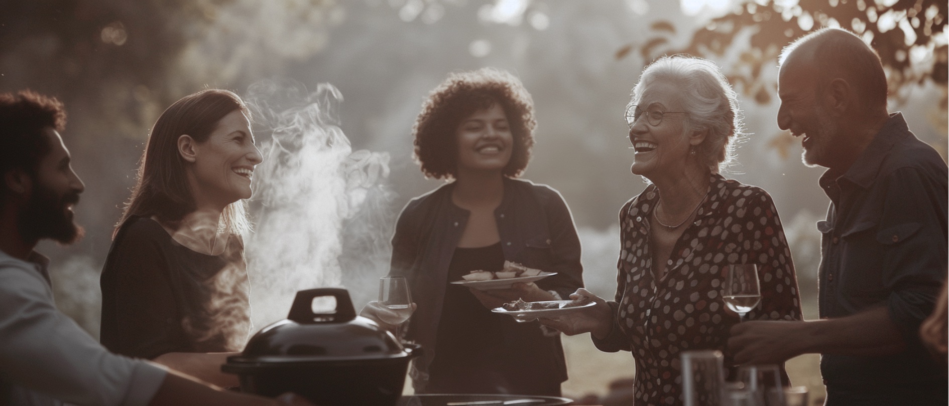 Mehrgenerational Gruppe von Freunden beim Grillen im Park, warmes Abendlicht